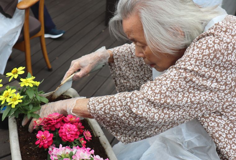 「次は何を植えようかしら？」と真剣な眼差しでお手伝いいただきました。※撮影のためマスクを外しています 