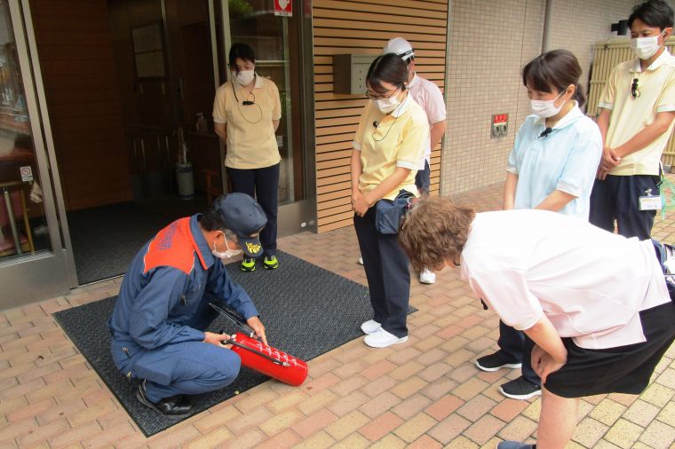 消防署の方から消火器の詳しい使用方法を学んでいます。消火訓練を初めて体験したスタッフもおり、効果的な訓練ができました。 