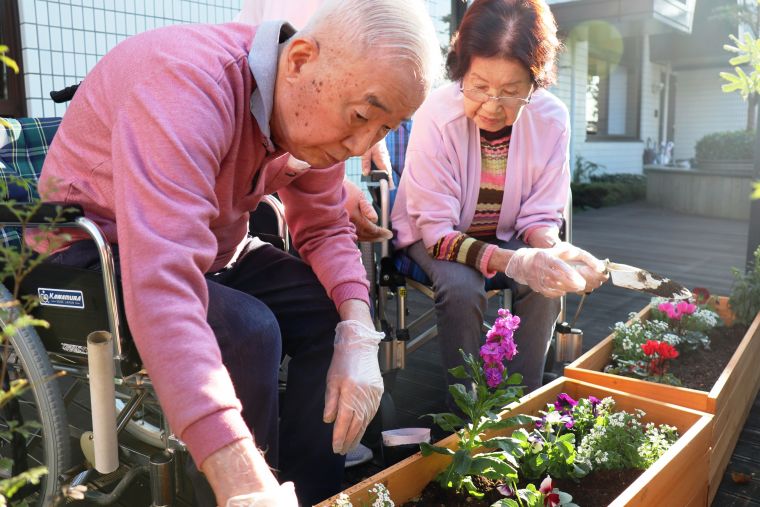 偶然にも秋桜色のセーター姿で真剣な眼差しの入居者様、全体の絶妙なバランスも上手く仕上がりました。※撮影のためマスクを外しています 