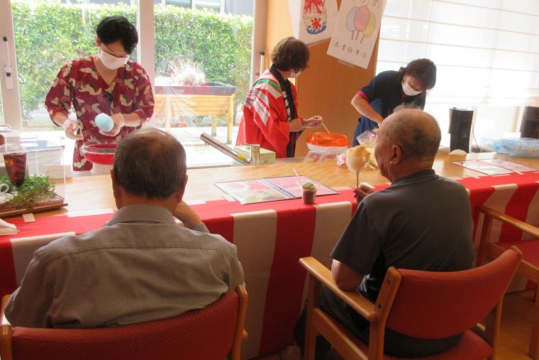 夏祭りらしい装いのスタッフが綿あめやかき氷をご入居者皆さんの目の前で作っておもてなし。スタッフの手つきもだんだん上達していきます。