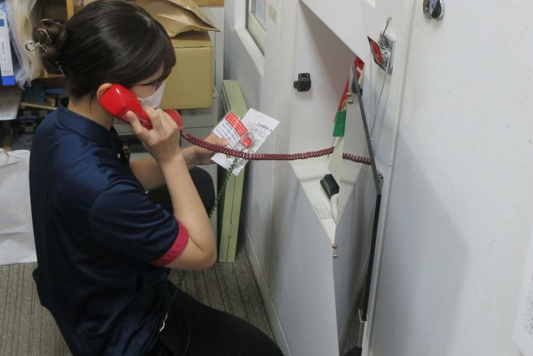 火災発生時の消防署への通報訓練を行っています。今回は火災専用電話と固定電話からの１１９番通報を訓練しています。