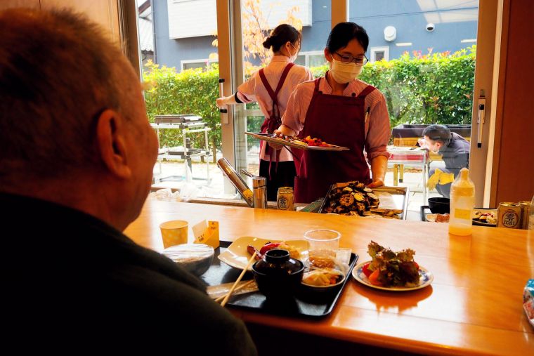 焼きたてのお肉や海鮮、野菜をキッチンスタッフが急いで盛り付け。温かいうちにご入居者へお届けしました。