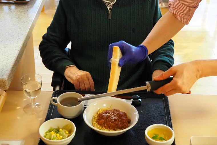 ご入居者の目前でチーズを削るのはイベント感たっぷり。削りたてチーズの見た目や味を楽しんでいただきました。